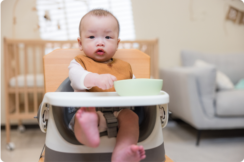baby with a bib being taking plate