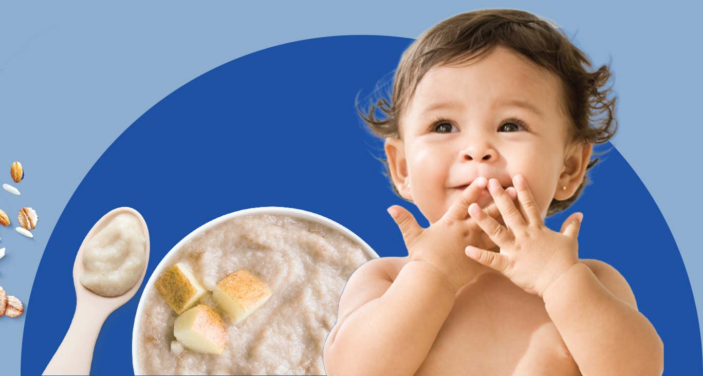 Cute baby sitting with a bowl of oatmeal in the background