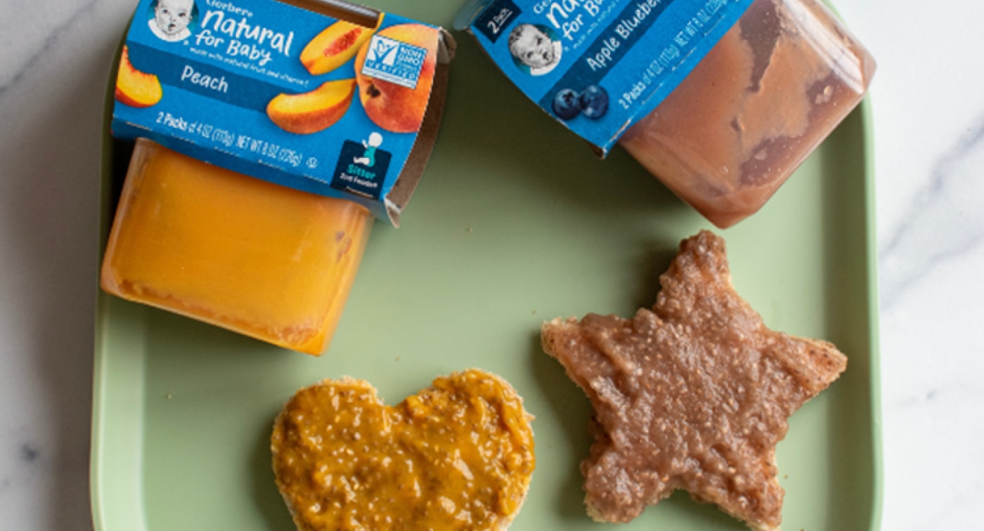 Bread cut in the shape of a heart and star with peach and apple blueberry puree jam spread on top.