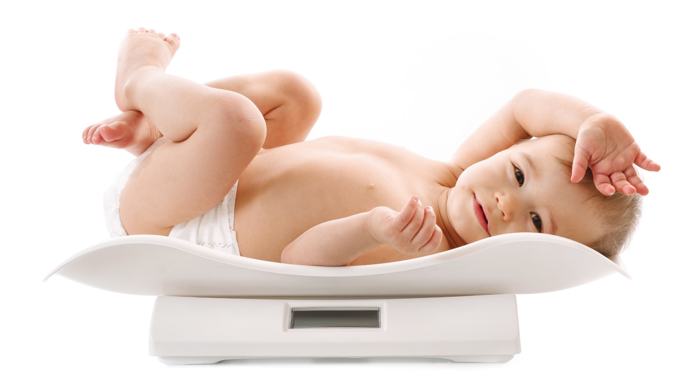 Baby in a diaper laying on a scale